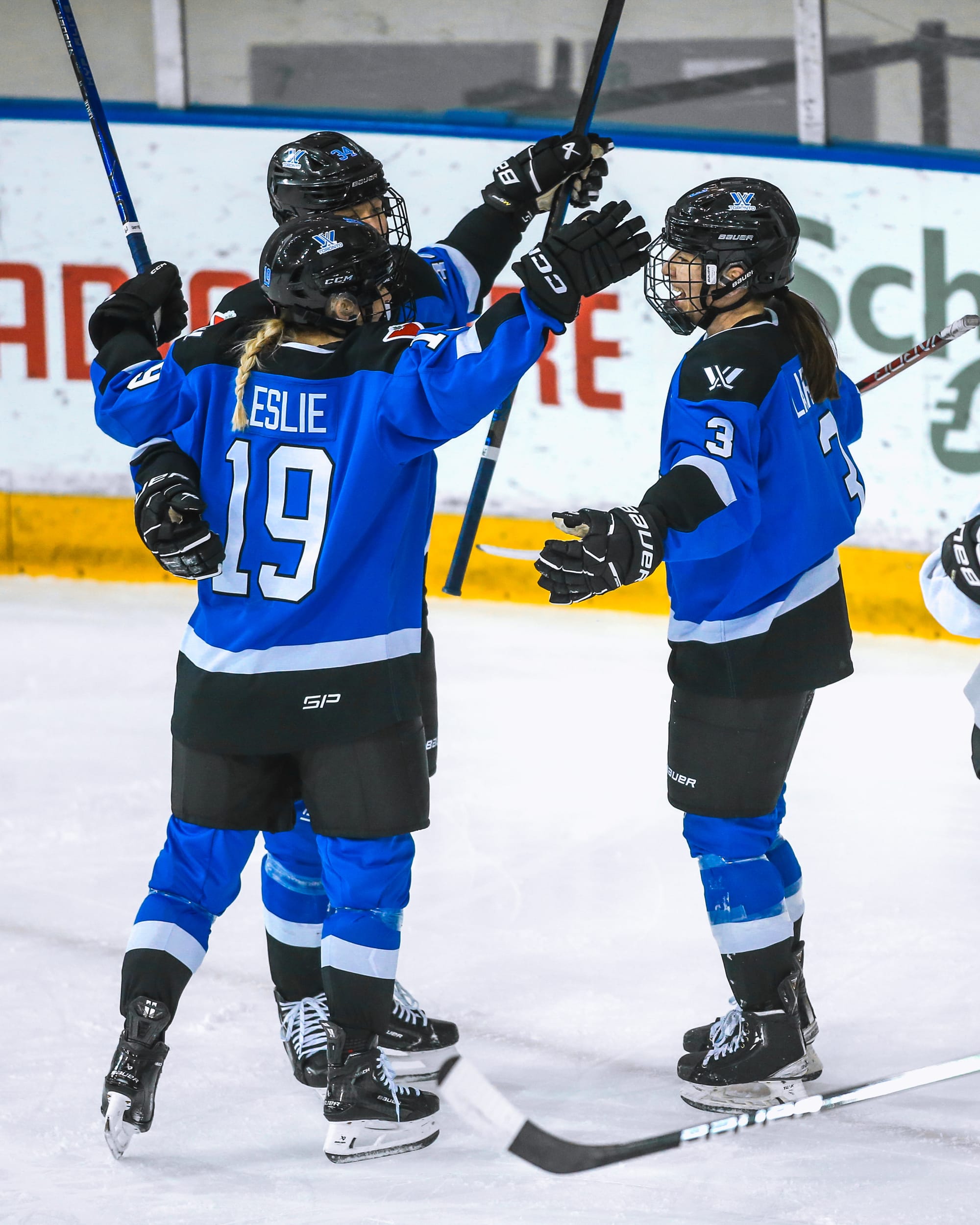 Toronto players, wearing their blue home uniforms, celebrate a goal against Boston.