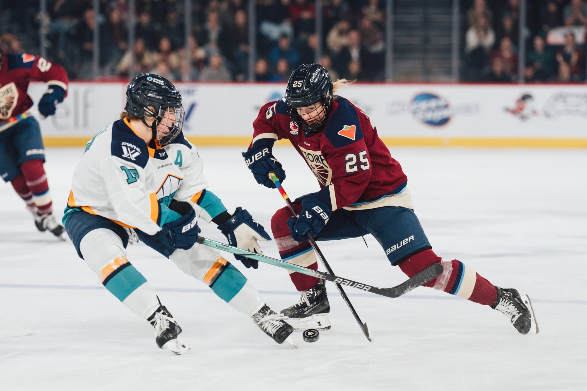 Ljungblom (right in maroon) dekes around a New York defender (left in white), who is trying to poke check her.
