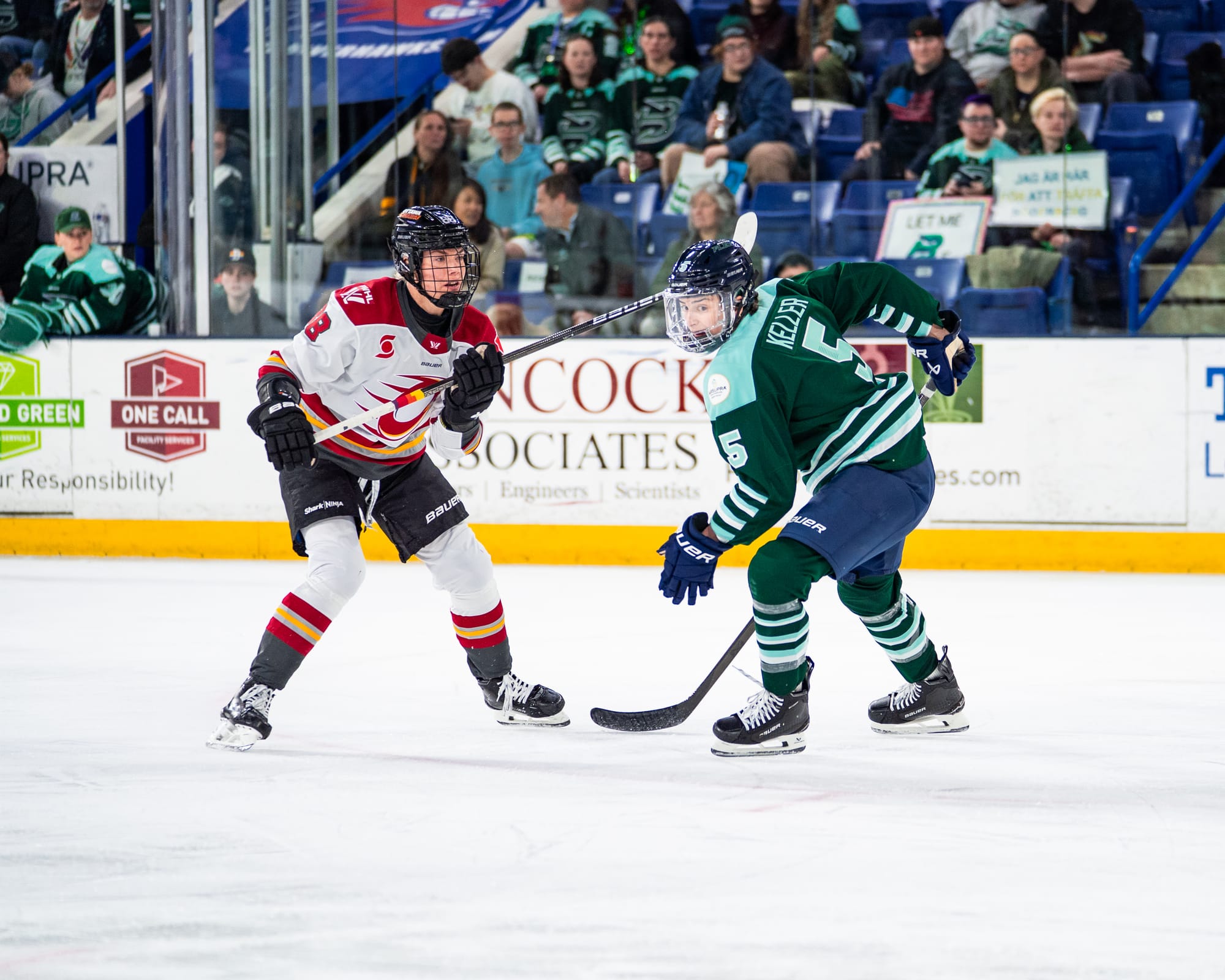 Keller (right in green) prepares to turn as the Ottawa player (left in white) watches the play.