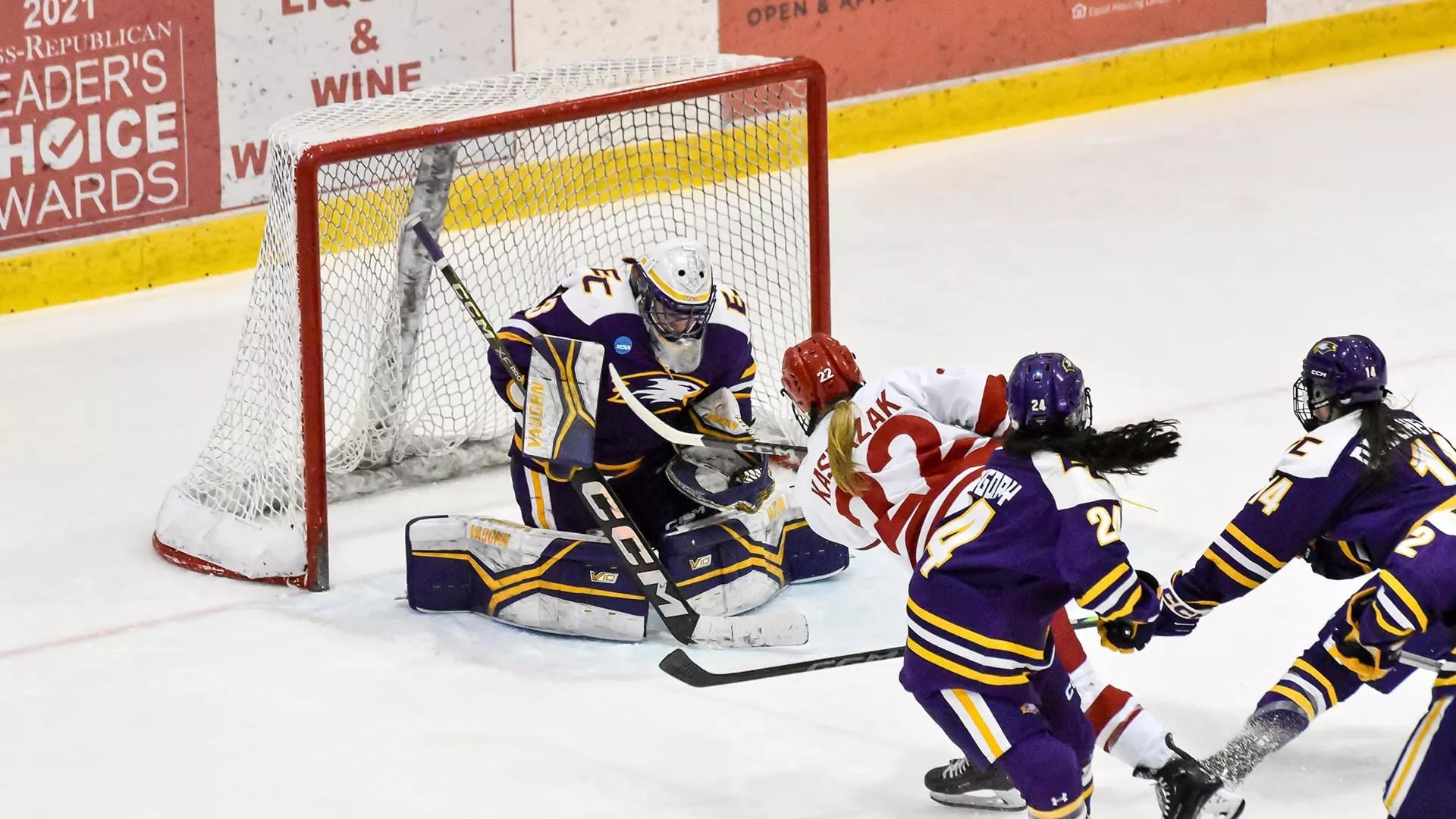 Plattsburgh's Emily Kasprzak, in white and red, has worked her way through two Elmira defenders in purple to take a shot that is saved by Elmira's goalie.