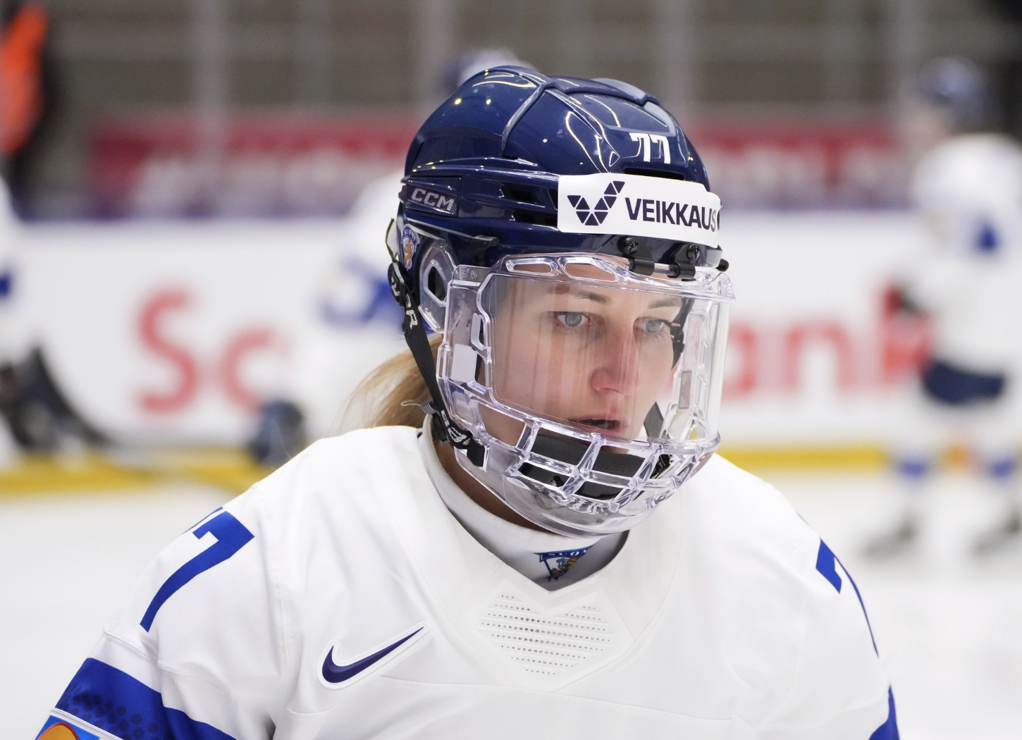 A shoulders-up shot of Susanna Tapani looking down at something out of frame. She is wearing a white uniform.