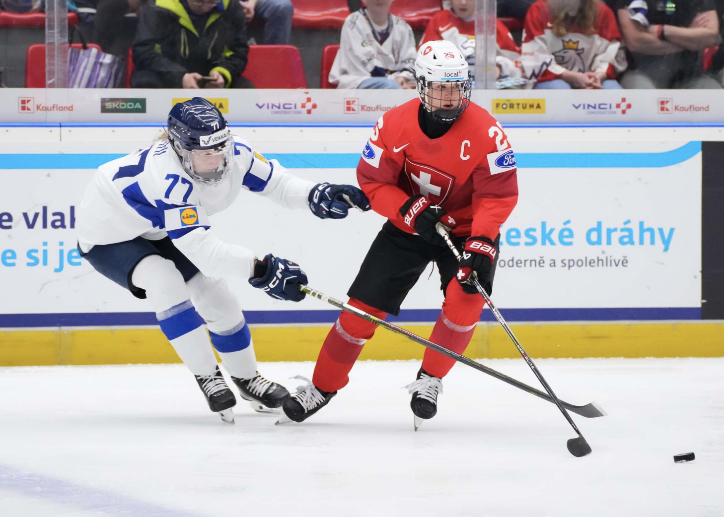 Müller (right in red) skated with the puck as Tapani (left in white) attempts to poke it away.
