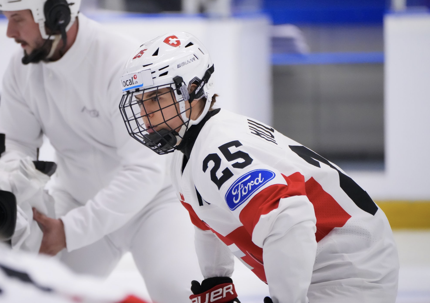A waist-up shot of Müller, who prepares for a faceoff against Czechia. She is looking to her left and wearing a white uniform.