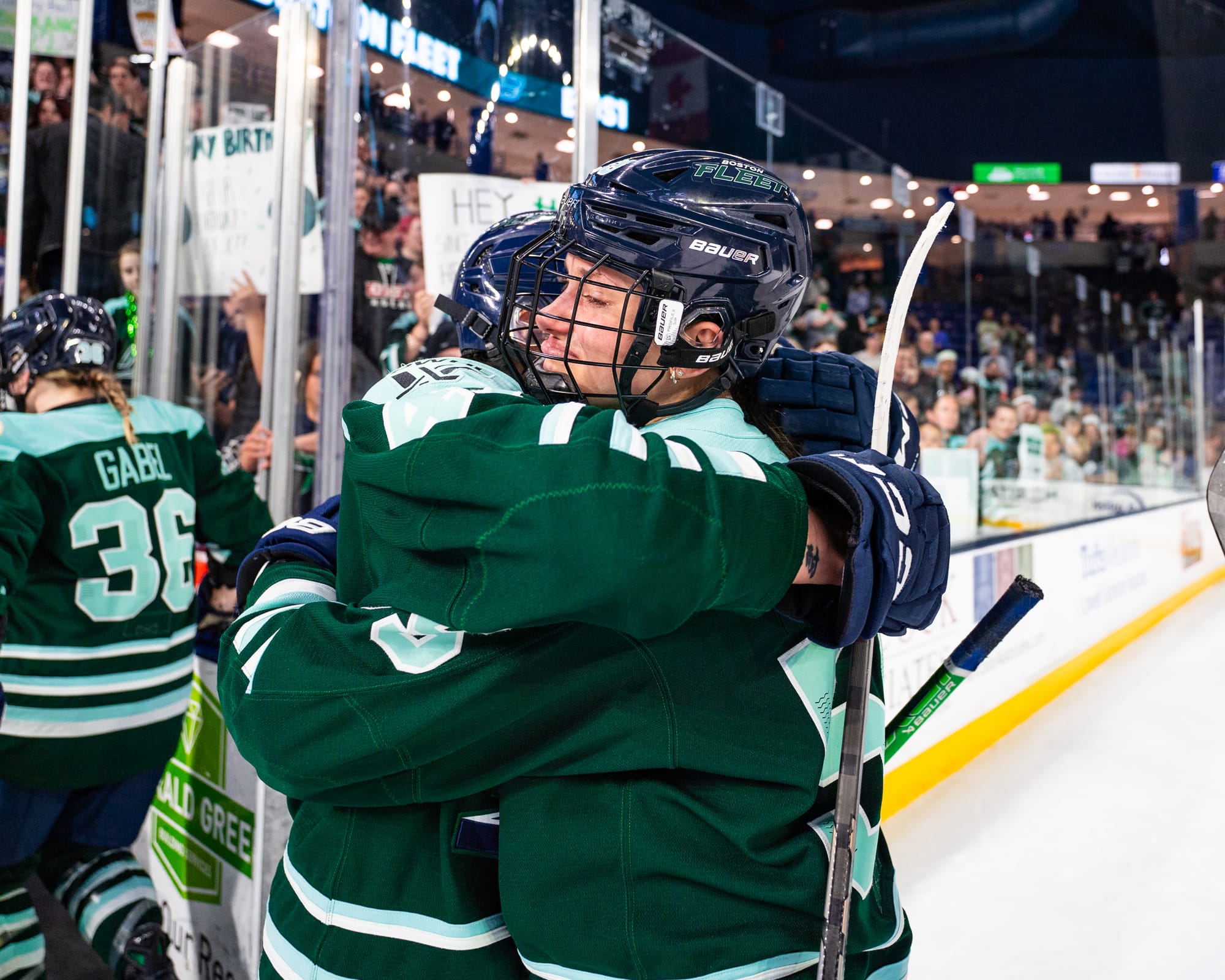 An upset Pejšová hugs her teammate. They are both wearing green uniforms.