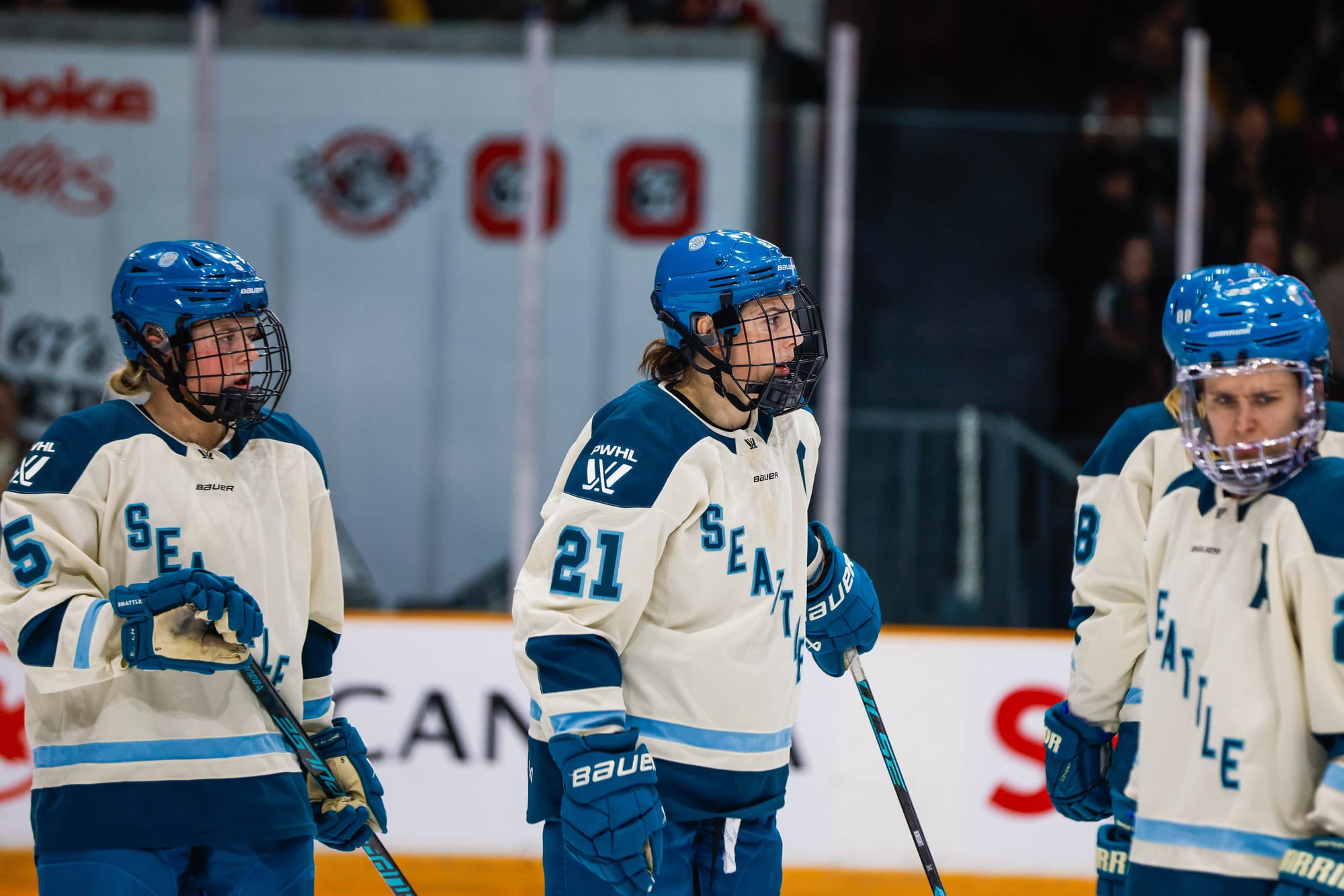 Anna Wilgren, Hilary Knight, and Alex Carpetner stand with frustrated looks on their faces during their game against Ottawa. They are all wearing cream away uniforms.