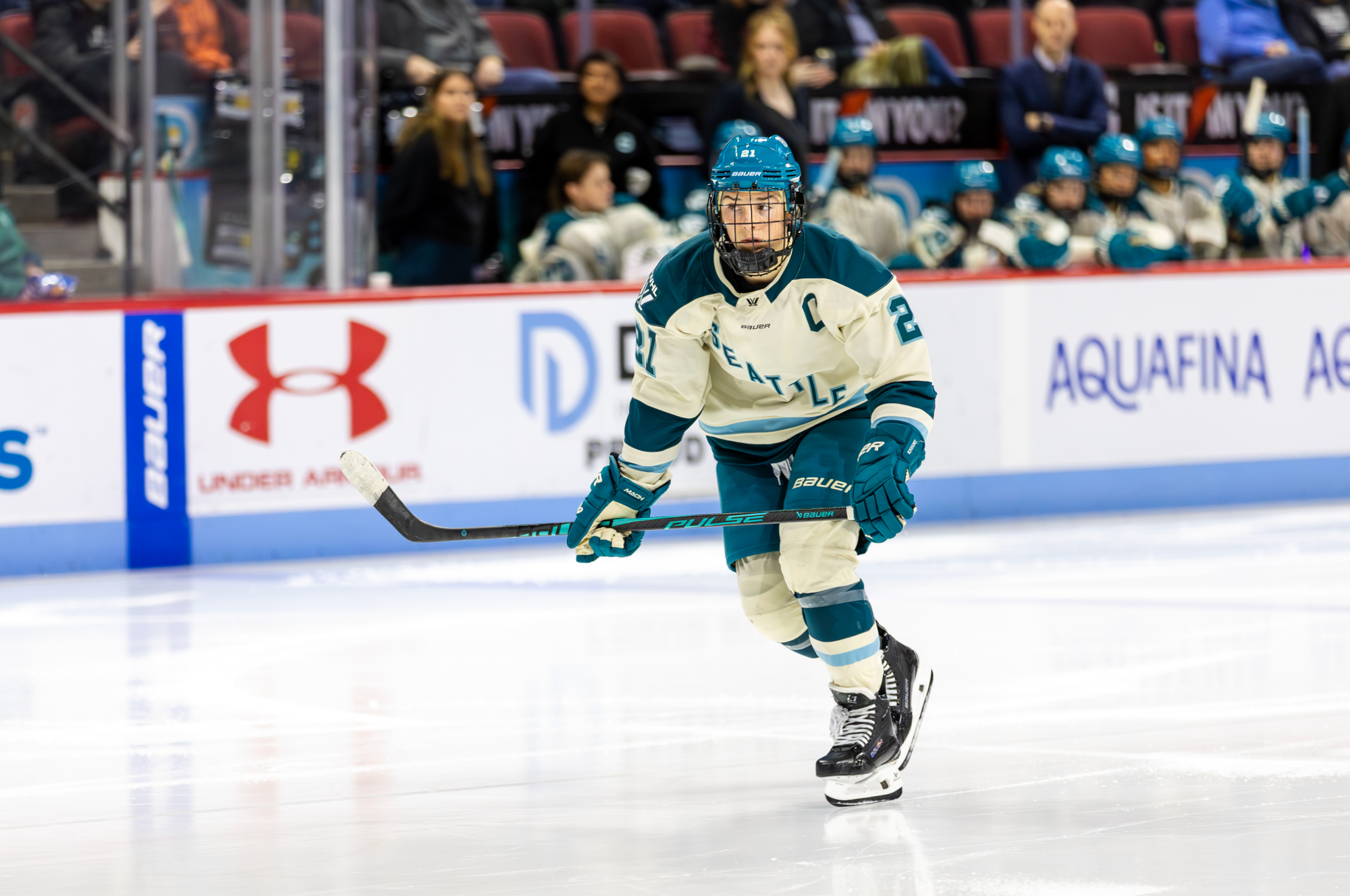 Knight skates toward the play, which is out of frame. She is wearing a cream away uniform.
