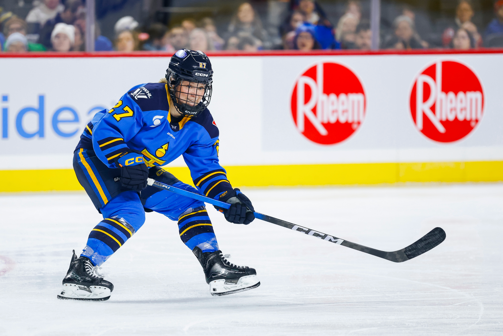 Maltais looks at the play out of frame and appears to await a pass. She is wearing a blue home uniform.