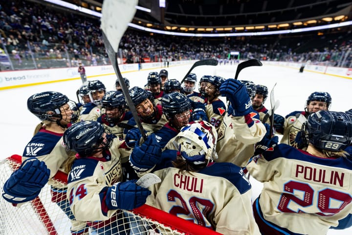 Montréal players celebrate with a group hug in front of their goal. They are wearing cream away uniforms.