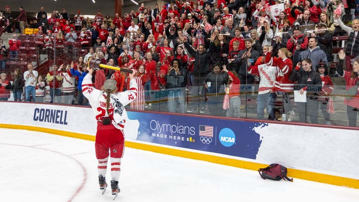National Championship game hero Kirsten Simms carries the trophy to the roar of fans