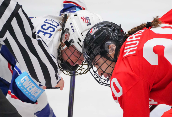 Heise and Nurse are both bent over, sticks on the ice. They're watching the puck as the ref prepares to drop it.