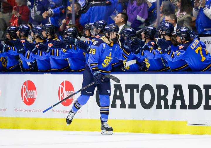 Gosling skates down the handshake line at the bench. She is wearing a blue home uniform.