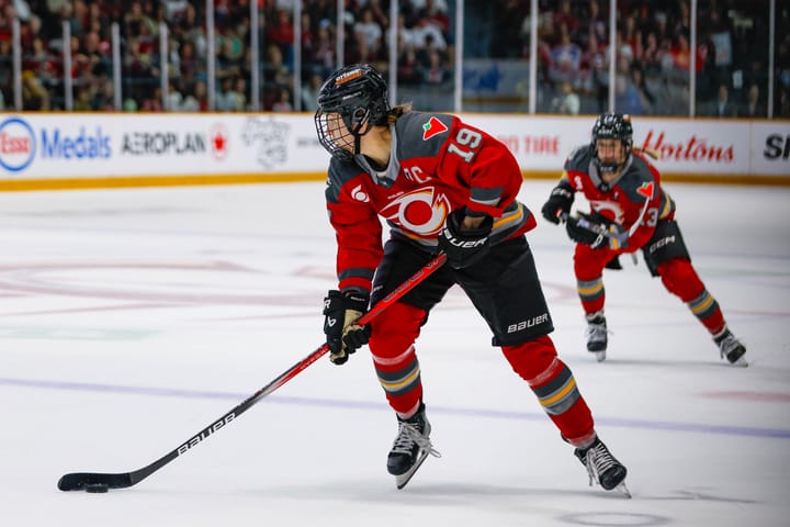 Brianne Jenner carries the puck into the z