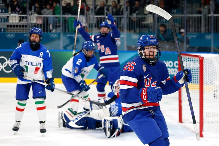 Coyne Schofield pumps her first in celebration against scoring against Italy. She is wearing a blue home uniform.